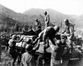 Medical corpsmen assist in helping wounded infantrymen down from an M39 armored utility vehicle