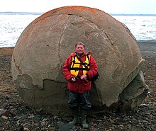 Rolf Stang vor der größten Steinkugel auf Franz-Josef-Land