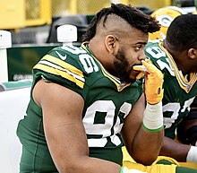 Keke sitting on a bench in his uniform during a game