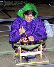 Anciã inuit a usar um qulliq, uma lâmpada ceremonial de óleo feita de serpentinite.