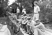 Habitants de Boothville, Louisiane assis sur un quai, 1938.