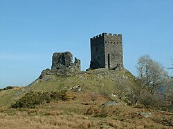 upon a grassy hillock stands two rectangular built fortifications. The one to the left is ruinous while the one to the right appears whole with battlements