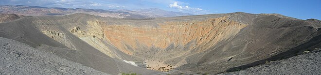 Vue d'une grande fosse aux couleurs désertiques.