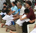 Image 35Display of respect of the younger towards the elder is a cornerstone value in Thailand. A family during the Buddhist ceremony for young men who are to be ordained as monks. (from Culture of Thailand)