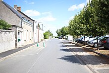 Photographie en couleurs d'une rue bordée de maisons.