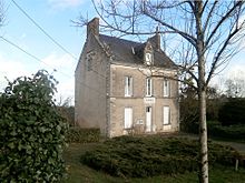 Photographie en couleurs d'un petit bâtiment à étage ; inscription « mairie » au-dessus de la porte.