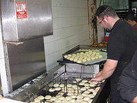 A baker deep-fries sufganiyot at the Mahane Yehuda Market, Jerusalem.