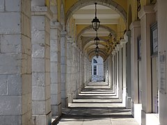 Photographie en couleurs d'un bâtiment dont le rez-de-chaussée est constitué d'arcades ouvertes.