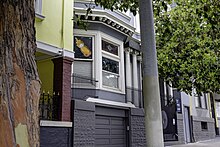 a honey bear print being displayed on a window inside of a gray house in San Francisco in August 2020