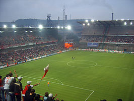 Stade Maurice Dufrasne: Standard Luik speelt tegen UN Käerjeng 97. Op de achtergrond een hoogoven van Arcelor in Ougrée en de Sart-Tilmanberg