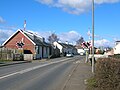 Looking towards the Cochrane Inn from the level crossing, the old post office and shop on the left.