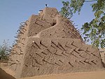 A mud structure with sticks protruding from the wall.