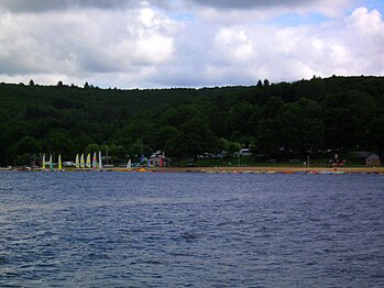 Leisure beach on the south side of the lake, with typical Plateau de Millevaches landscape in the background