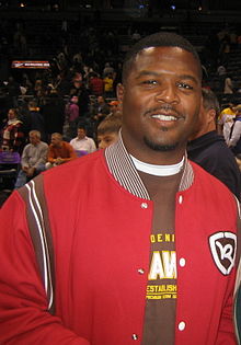 Butler wearing a red jacket with a crowd behind him