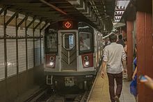 A subway train and many people are seen in New York City's subway system.