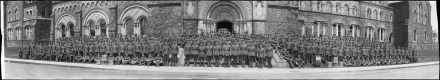 Photographie en noir et blanc de militaires se tenant devant un bâtiment