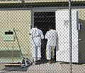 Two detainees in white "uniforms" stand in the doorway of their bay in Camp 4.