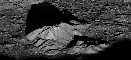 El pico central del cráter Tycho, proyectando una larga y oscura sombra durante el amanecer local.