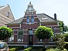 Groot representatief woonhuis op rechthoekige plattegrond. Symmetrische gevelopzet met centrale entree en topgevel met stijlverwijzingen naar Hollandse Neorenaissance. Pand met begane grond en kapverdieping.