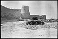 A photograph of the wall of Qatif Castle, featuring one of its towers, taken in 1930 AD.