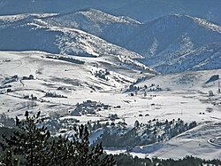 A landscape of the small town Semegnjevo with snow covered mountains