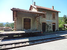 Petite gare de Mézel, avec wagon plat devant le hangar à marchandises précédé d'un vaste auvent, et bâtiment voyageur à étage.