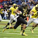 A picture of Derrick Henry running with a football during a game.