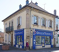 Enseigne de l'office de tourisme et vitrine dans un bâtiment ancien.