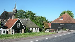 Dorpsgezicht van Kolhorn met rechts een turfboet en op de achtergrond de kerk