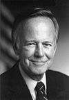 Black-and-white photo of a man in a suit smiling