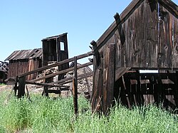 Photograph of several weatherworn, dilapidated buildings