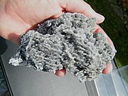 Rows of colorless calcite crystals held together by layers of papery palygorskite. From Metaline Falls, Washington, USA, 2013.