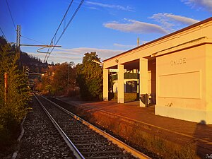 Single-tracked railway line next to squat, one-story building