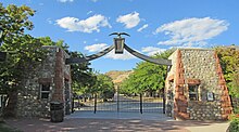 An image of a gate, with cobblestone pillars and an eagle statue on top.