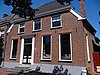 Markt 12: Boerderij met wolfdak, deuromlijsting van pilasters met hoofdgestel en stoep