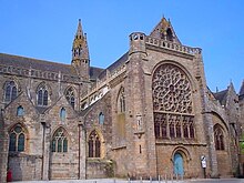 Photographie d'un bras de transept d'église avec une grande rose.