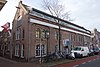 Pakhuis/fabriekspand in sobere eclectische trant uit de tweede helft van de 19de eeuw en naastgelegen kolenloods in art-nouveautrant uit 1906, in 1939 samengevoegd tot één bedrijfspand