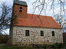 Stone building with three windows, red roof and brick bell tower