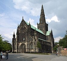 black weathered stone cathedral showing west front stained glass window