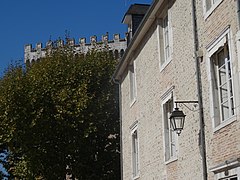 Photographie en couleurs d'un vieille immeuble construit en galets et briques.