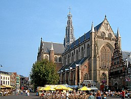 El exterior de la Gran Iglesia de Haarlem. Los arbotantes han sido suprimidos, pero el gran vitral de la fachada, típicamente brabanzón, está bien presente.