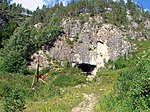 Entrance to a cave, surrounded by trees