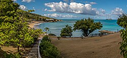 View of Sea Grapes Beach at the Rex Resorts’ Hawksbill Hotel at Five Islands with world’s largest yacht at anchor off Hawksbill Bay.