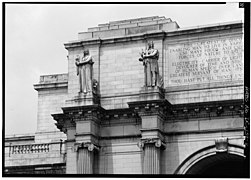 Detail of the west end of the main entrance pavilion, showing statuary and inscription