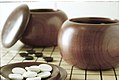 Image 5An example of single-convex stones and Go Seigen bowls. These particular stones are made of Yunzi material, and the bowls of jujube wood. (from Go (game))