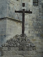 Le calvaire est érigé sur un piédestal, et orné des instruments de la Passion