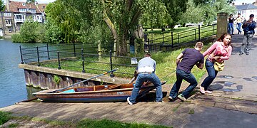 A punt being pulled up rollers between the upper and lower levels of the river