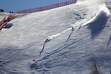 Skier and guide skier skiing down a mountain