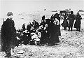 Members of the 21st Latvian Police Battalion assemble a group of Jewish women for execution on a beach near Liepāja, 1941.