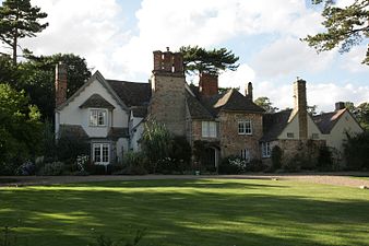 A large farmhouse with many red-brick chimneys